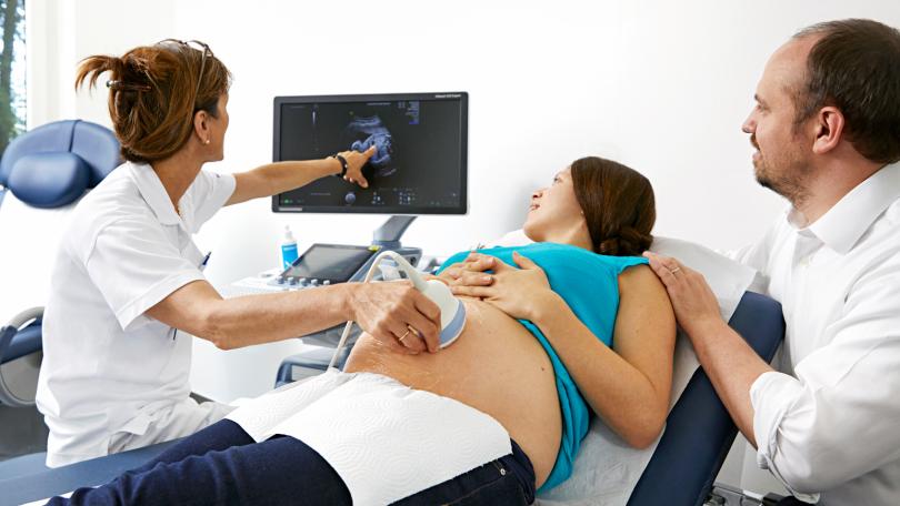 Ärztin führt eine Ultraschalluntersuchung an einer schwangeren Frau durch