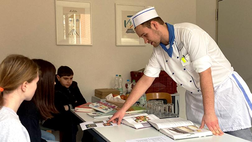 Ein Koch gibt Schülerinnen und Schüler Einblick in seinen Alltag.